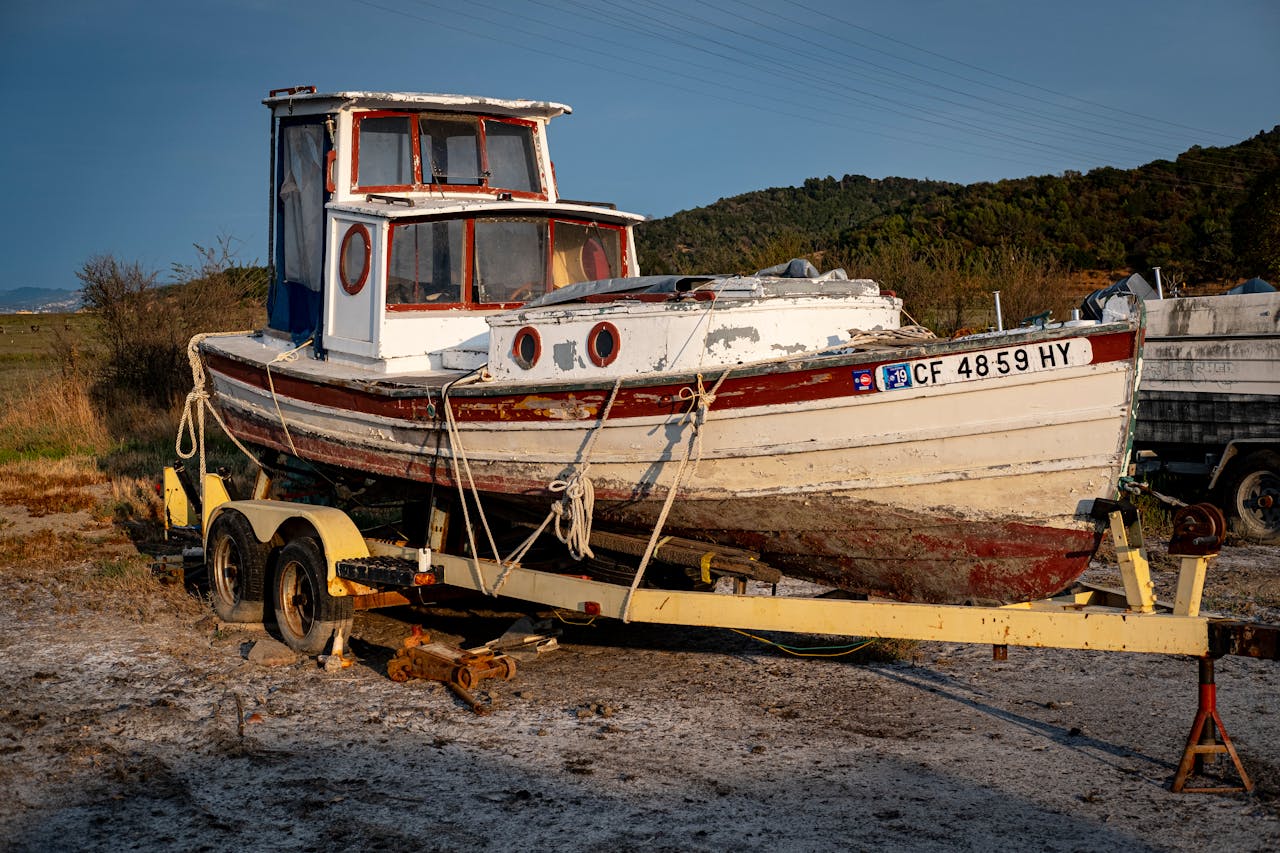 Old fishing boat on a trailer by the seashore, ideal for nautical themes.